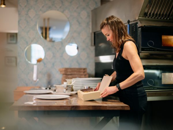 Frisch zubereitet zum Mitnehmen Mitarbeiterin bereitet eine Takeaway-Bestellung im Restaurant Jahn am Kellerplatz vor
